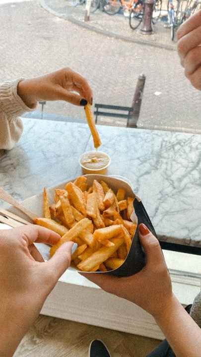 Sfeerbeeld: friet delen aan tafel (Unsplash)